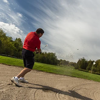 Golfer hitting a ball out of a sandtrap