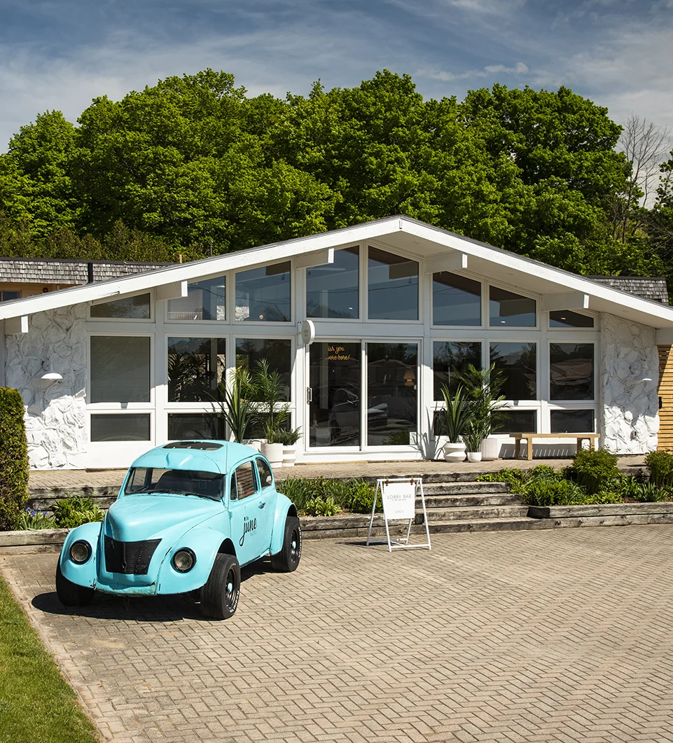 VW Bug in front of a motel reception building