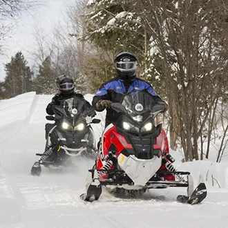 Two snowmobilers on a trail